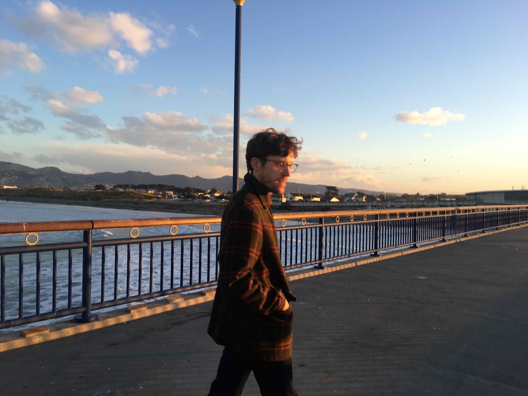 A person in the glow of evening sun standing on a wharf